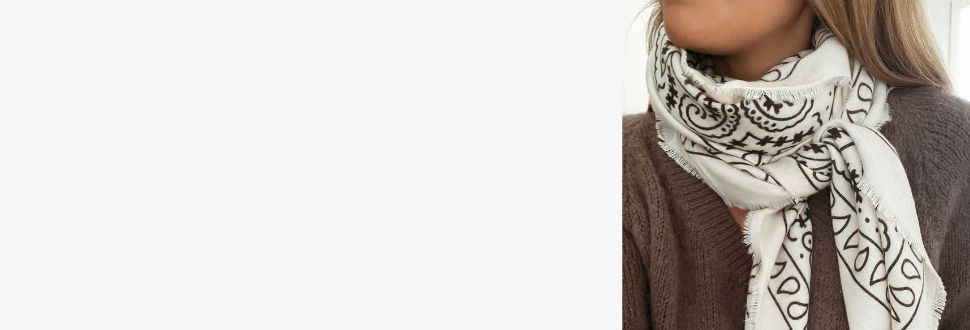 Femme portant une écharpe blanche à motifs noirs Sozely, accessoire élégant et abordable à moins de 50 euros.