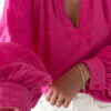 Blouse rose fuchsia fluide portée avec un jean blanc taille haute et bijoux dorés