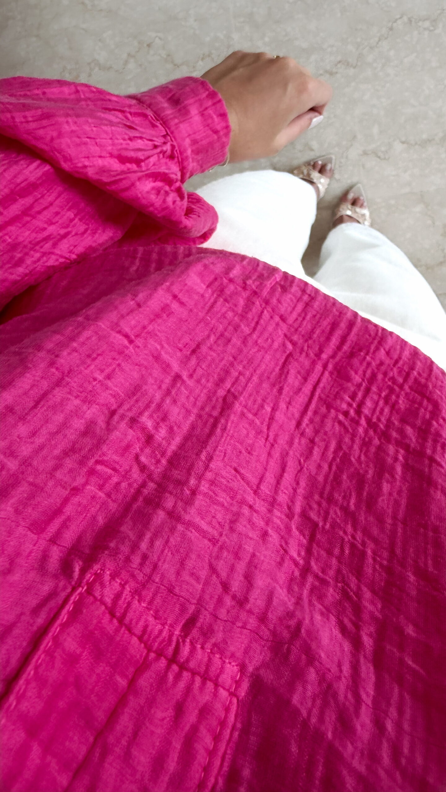 Blouse rose fuchsia fluide portée avec un jean blanc taille haute et bijoux dorés