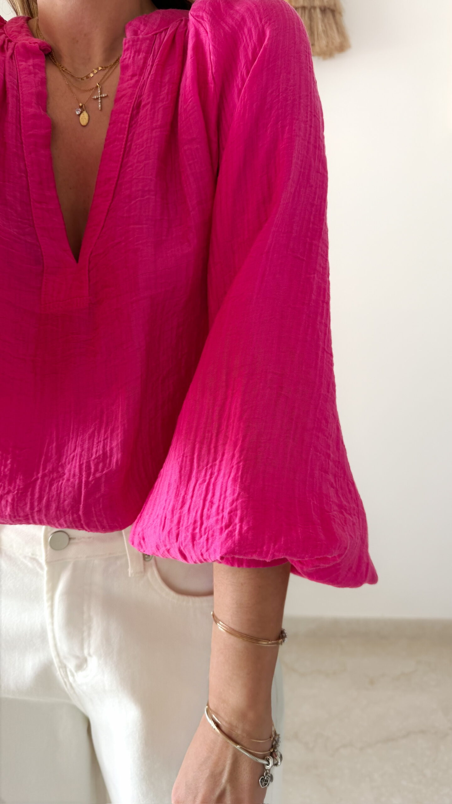 Blouse rose fuchsia fluide portée avec un jean blanc taille haute et bijoux dorés