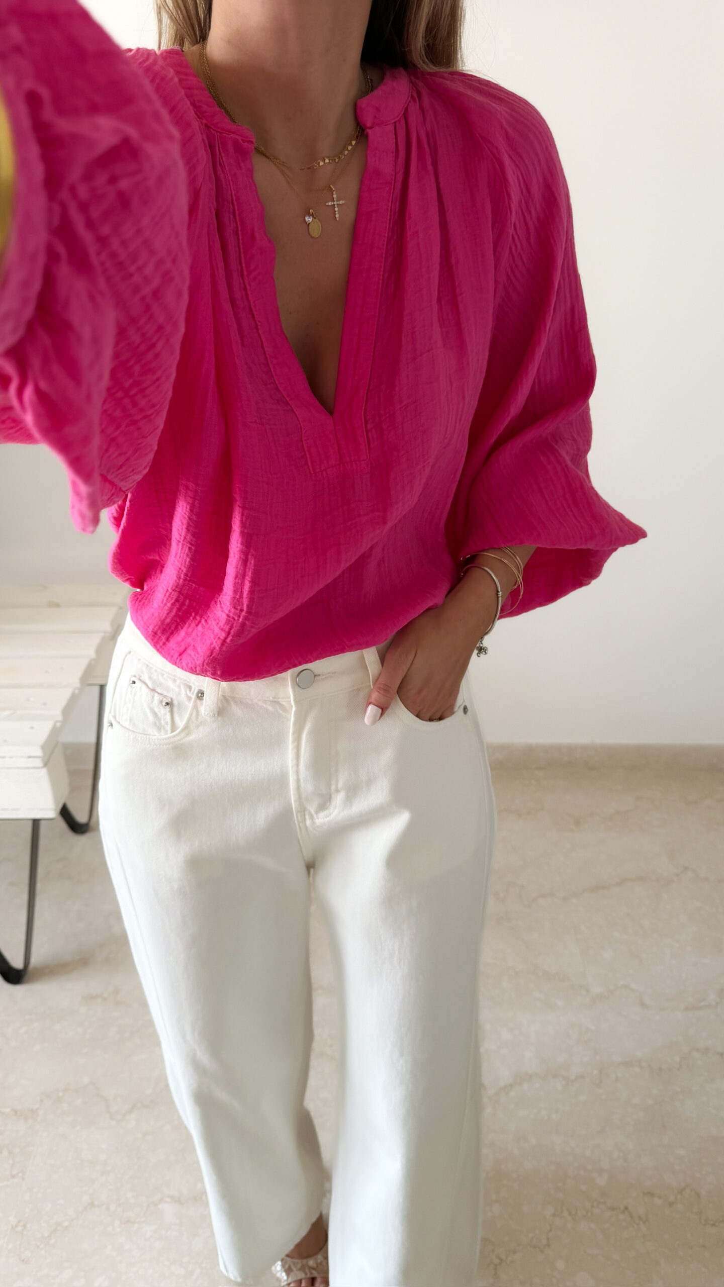 Blouse rose fuchsia fluide portée avec un jean blanc taille haute et bijoux dorés