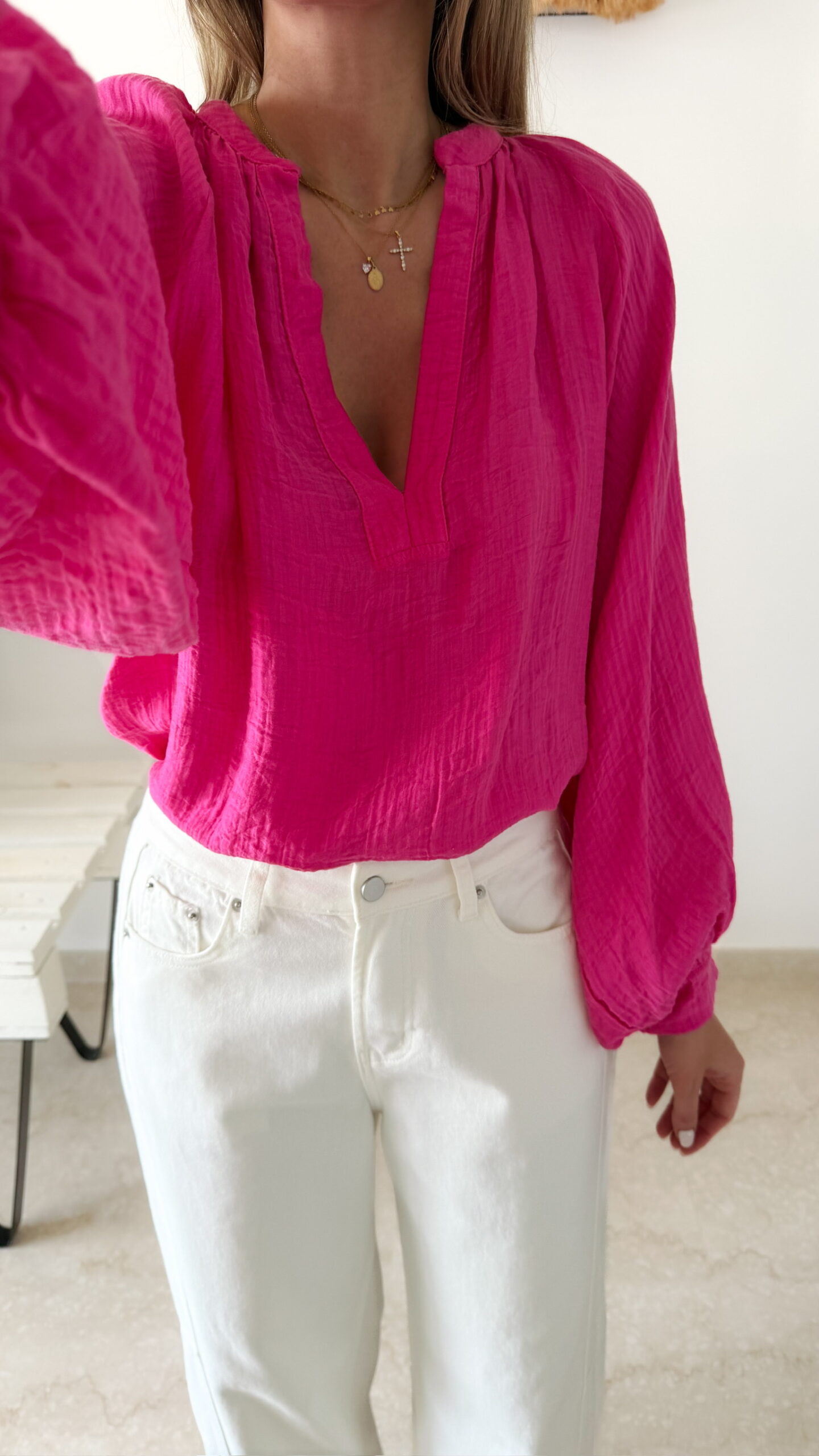 Blouse rose fuchsia fluide portée avec un jean blanc taille haute et bijoux dorés
