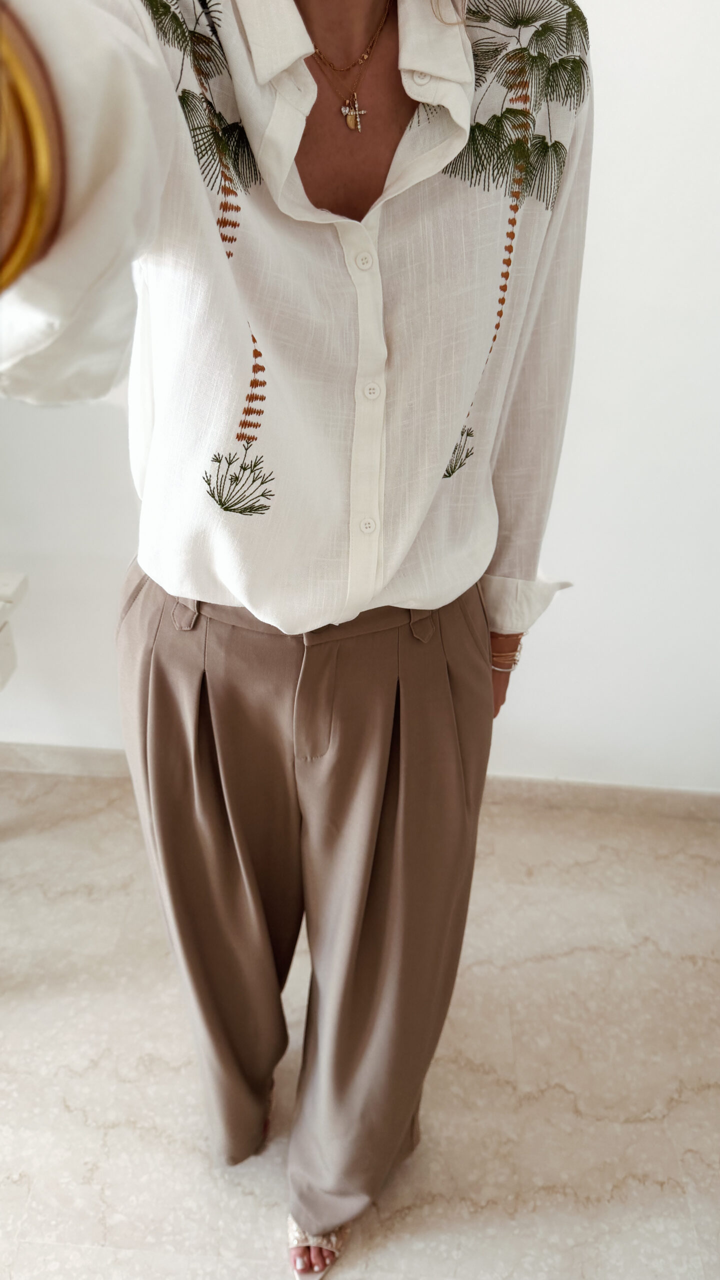 Chemise blanche fluide avec broderies palmier, une pièce élégante aux inspirations naturelles et estivales.