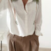 Chemise blanche fluide avec broderies palmier, une pièce élégante aux inspirations naturelles et estivales.