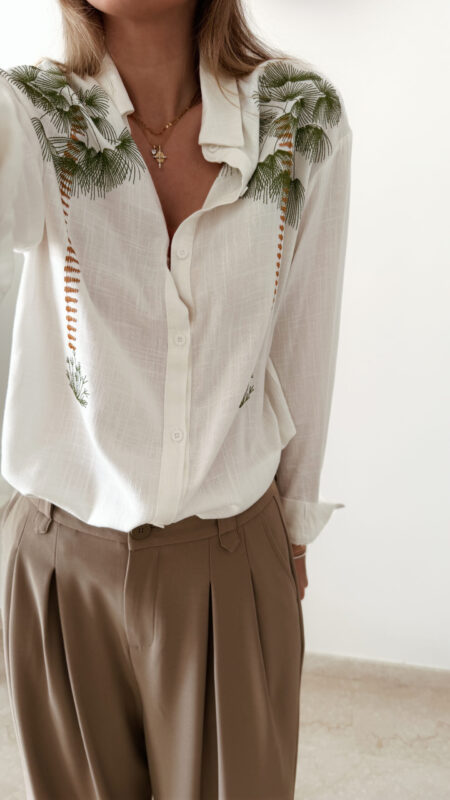 Chemise blanche fluide avec broderies palmier, une pièce élégante aux inspirations naturelles et estivales.