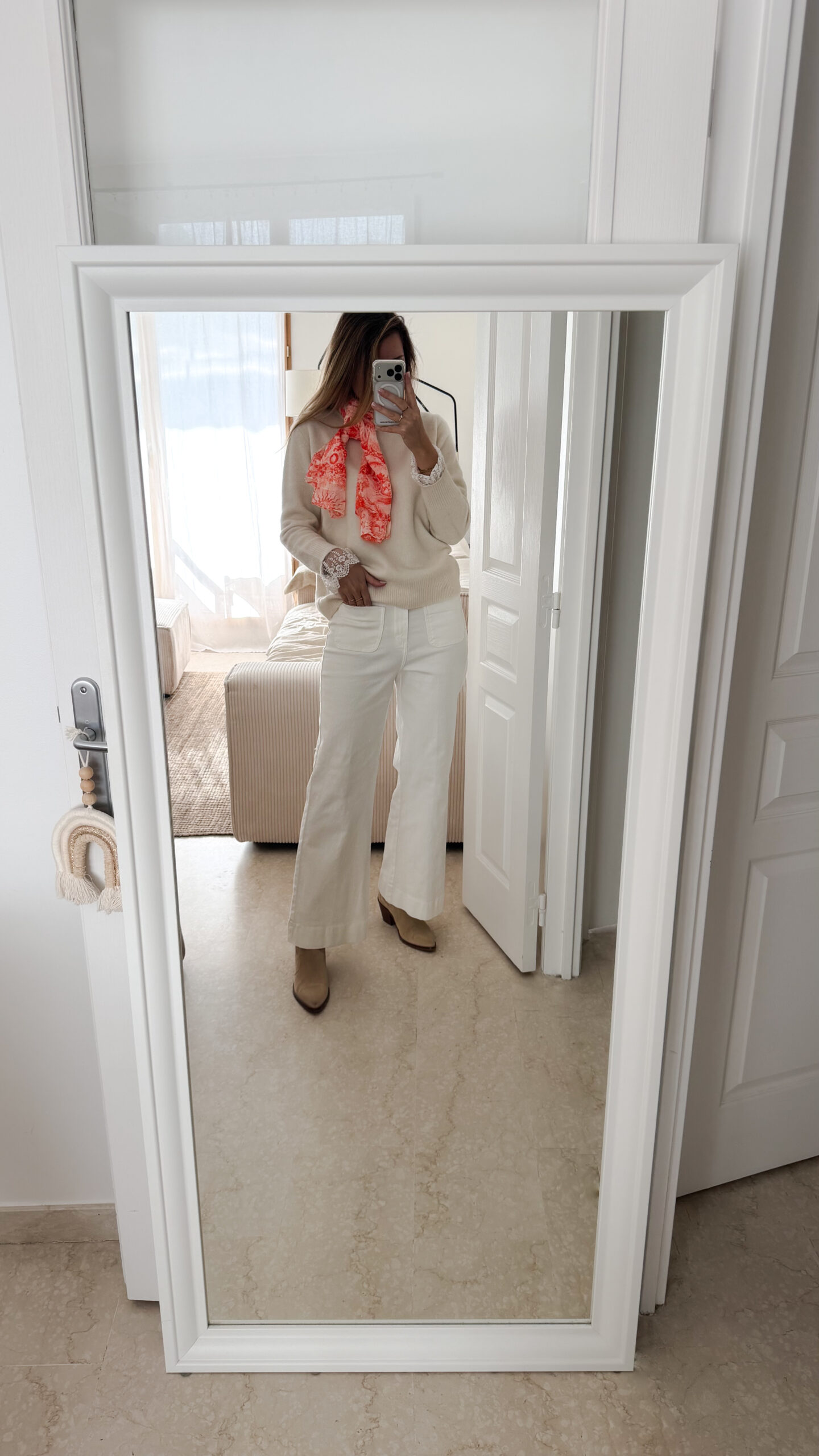 Foulard rose et orange motif Toile de Jouy porté avec pull beige et pantalon blanc