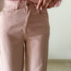 Pull rose doux à col volanté avec boutons perles porté avec un pantalon rose coupe droite.
