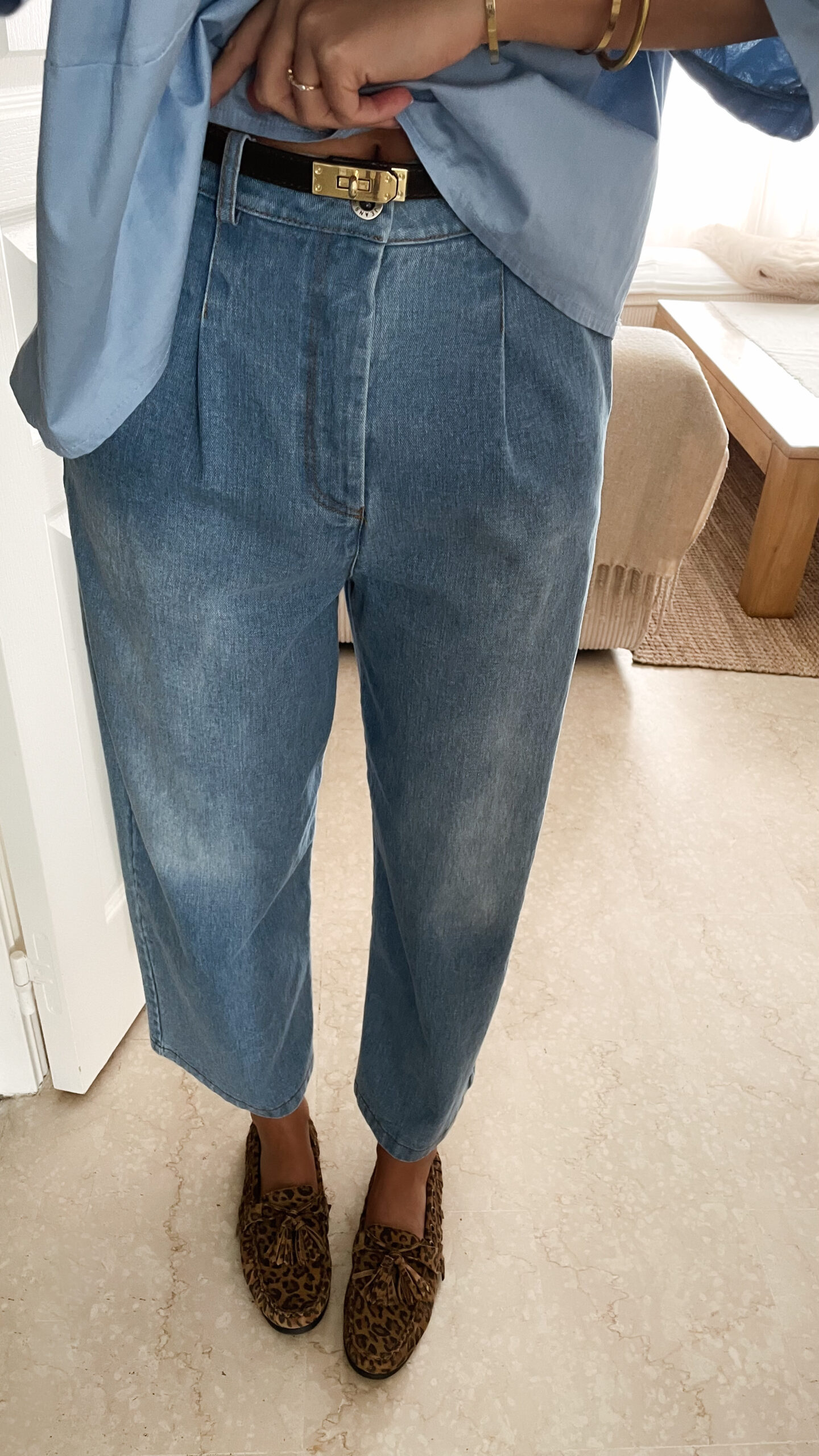 Vetement de femme avec la blouse Celine bleue volantée, le sac fourrure ecru bourse et le jean gabriel bleu clair