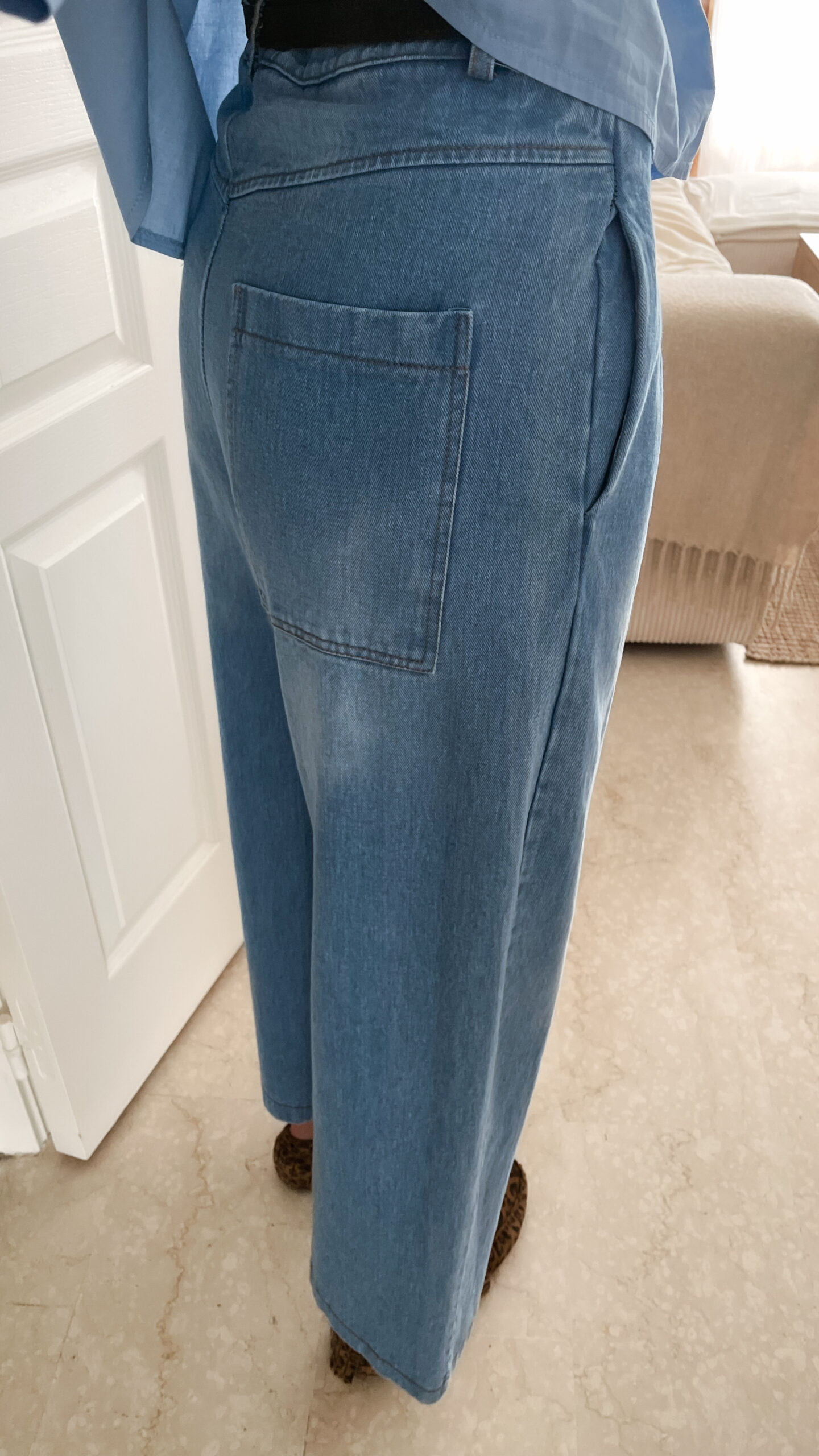 Vetement de femme avec la blouse Celine bleue volantée, le sac fourrure ecru bourse et le jean gabriel bleu clair