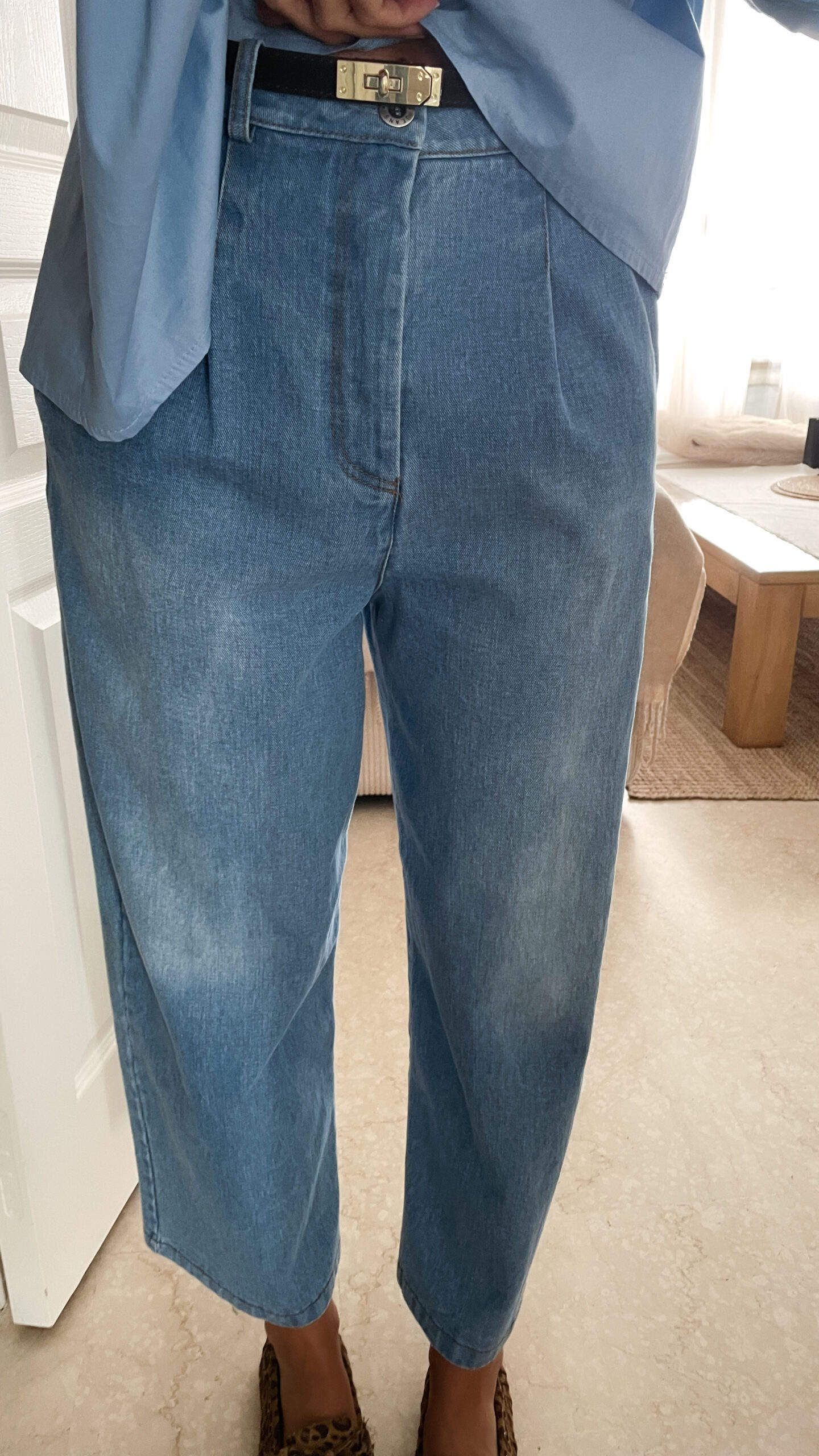 Vetement de femme avec la blouse Celine bleue volantée, le sac fourrure ecru bourse et le jean gabriel bleu clair