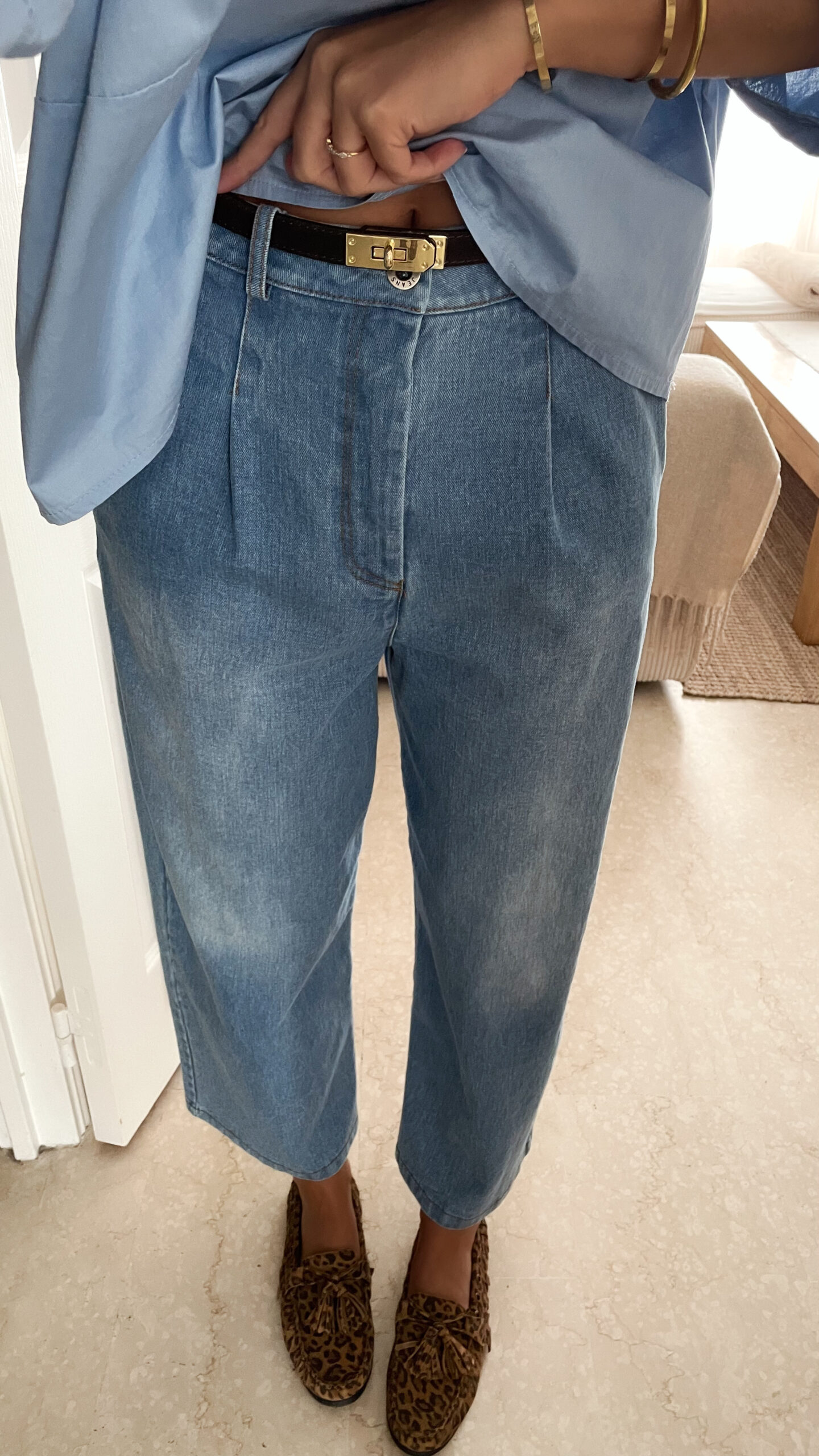 Vetement de femme avec la blouse Celine bleue volantée, le sac fourrure ecru bourse et le jean gabriel bleu clair