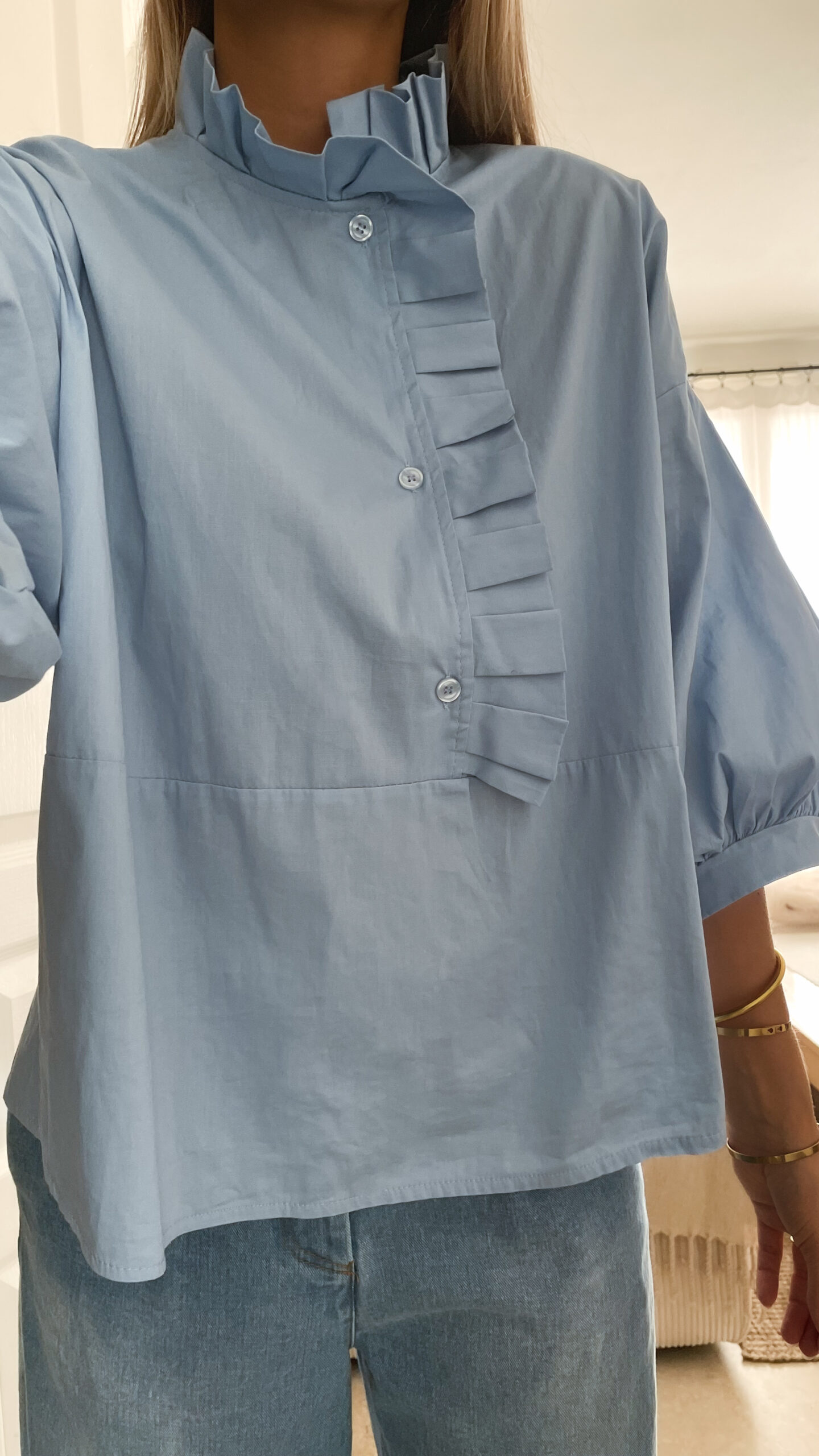 Vetement de femme avec la blouse Celine bleue volantée, le sac fourrure ecru bourse et le jean gabriel bleu clair