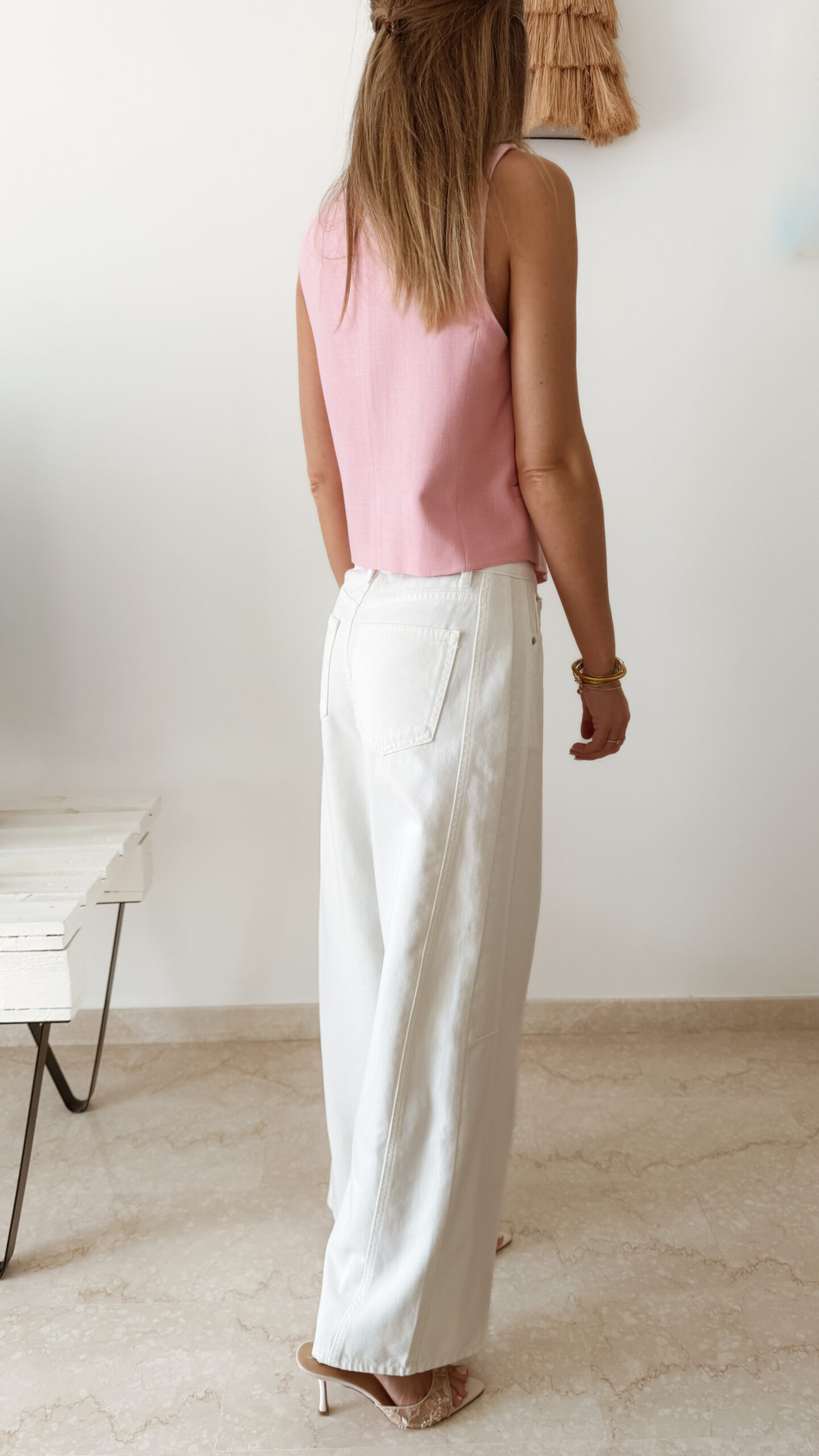 Gilet sans manches à boutons avec finition dentelle, une pièce élégante et féminine disponible en rose et jaune.