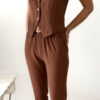 Femme portant un ensemble marron composé d’un gilet sans manches boutonné et d’un pantalon fluide taille haute.