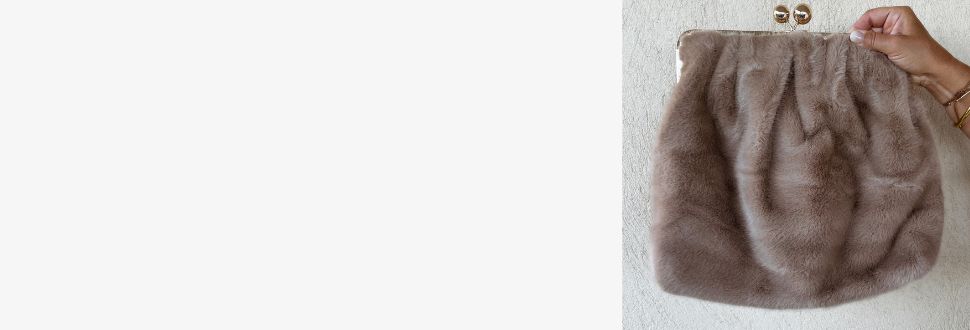 Sac à main en fausse fourrure beige taupe Sozely tenu à la main, accessoire phare de la collection best-sellers.