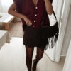 Femme portant un pull en mohair bordeaux à manches courtes, orné de boutons strass, associé à un foulard beige à motifs et des bijoux dorés au poignet.
