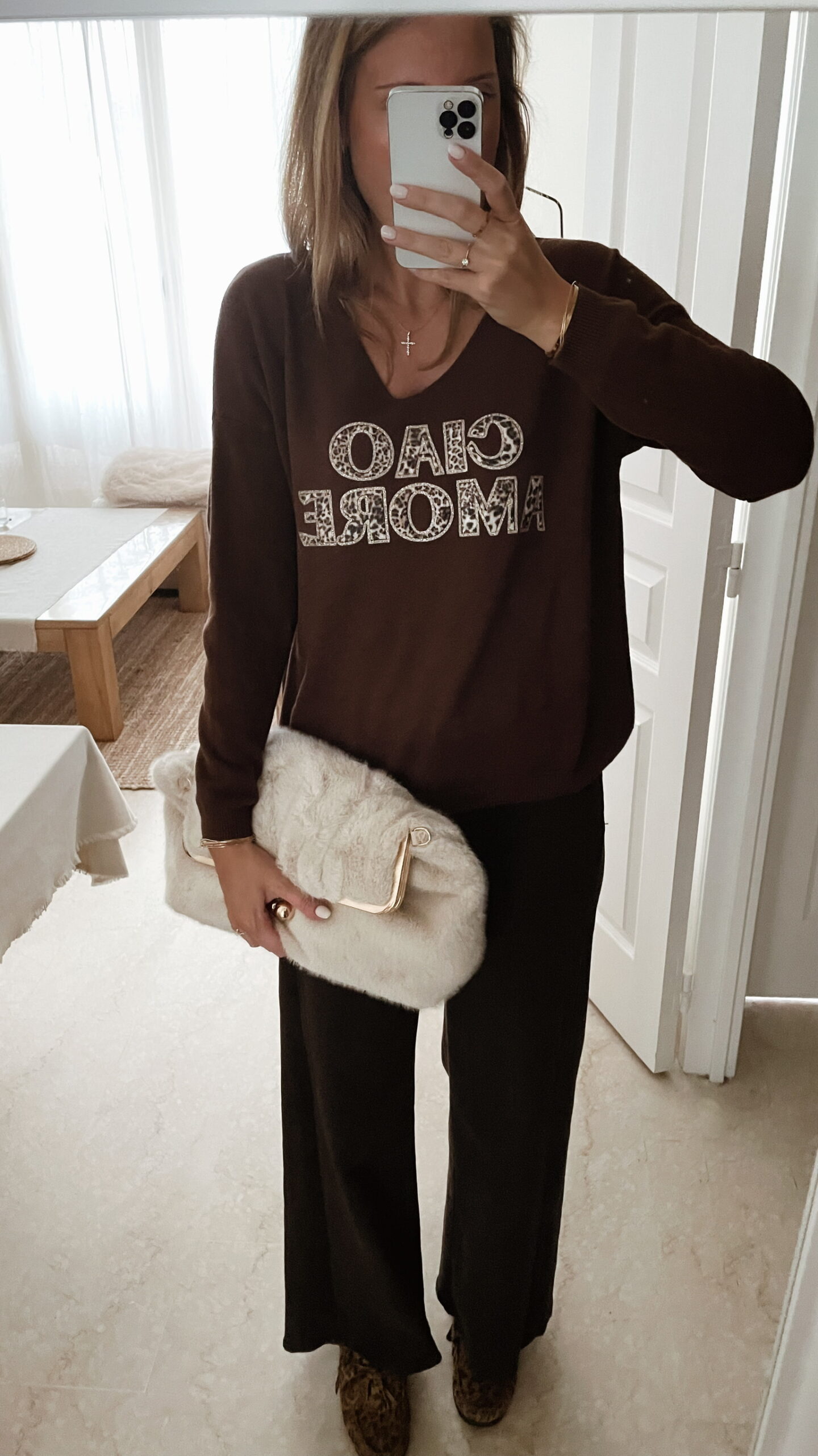 Femme portant un pull chocolat à inscription "Ciao Amore", associé à une écharpe imprimée beige et un pantalon foncé, pour un look automnal chic et décontracté.