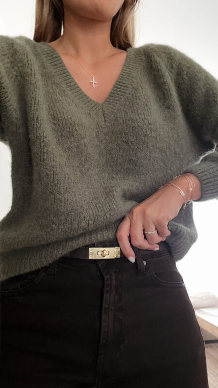 Femme portant un pull doux en alpaga couleur kaki, associé à un pantalon marron foncé à jambe large, une ceinture fine dorée, et des mocassins imprimés léopard.