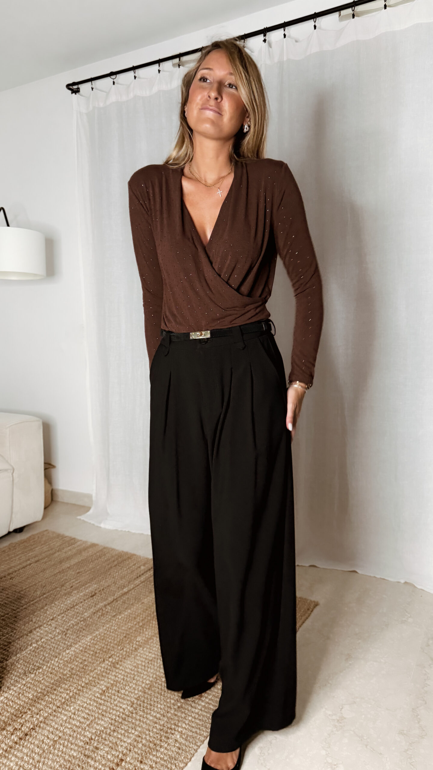 « Femme portant un body marron cache-cœur orné de strass, associé à un pantalon noir élégant »