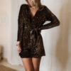 Femme portant une combinaison short à sequins marron avec manches longues et ceinture nouée à la taille.