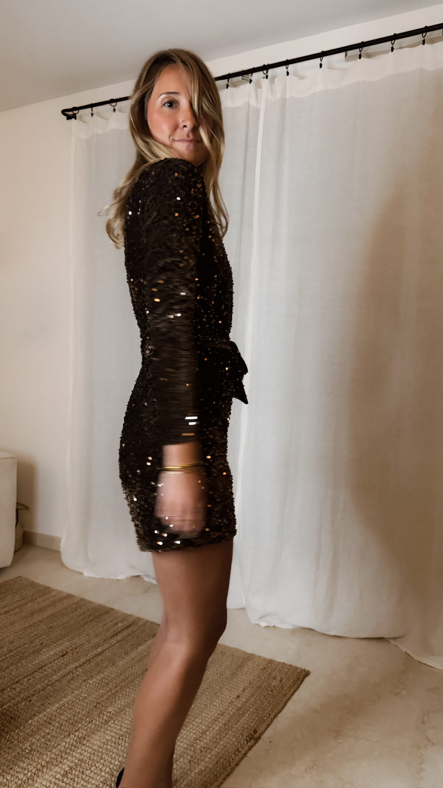 Femme portant une combinaison short à sequins marron avec manches longues et ceinture nouée à la taille.