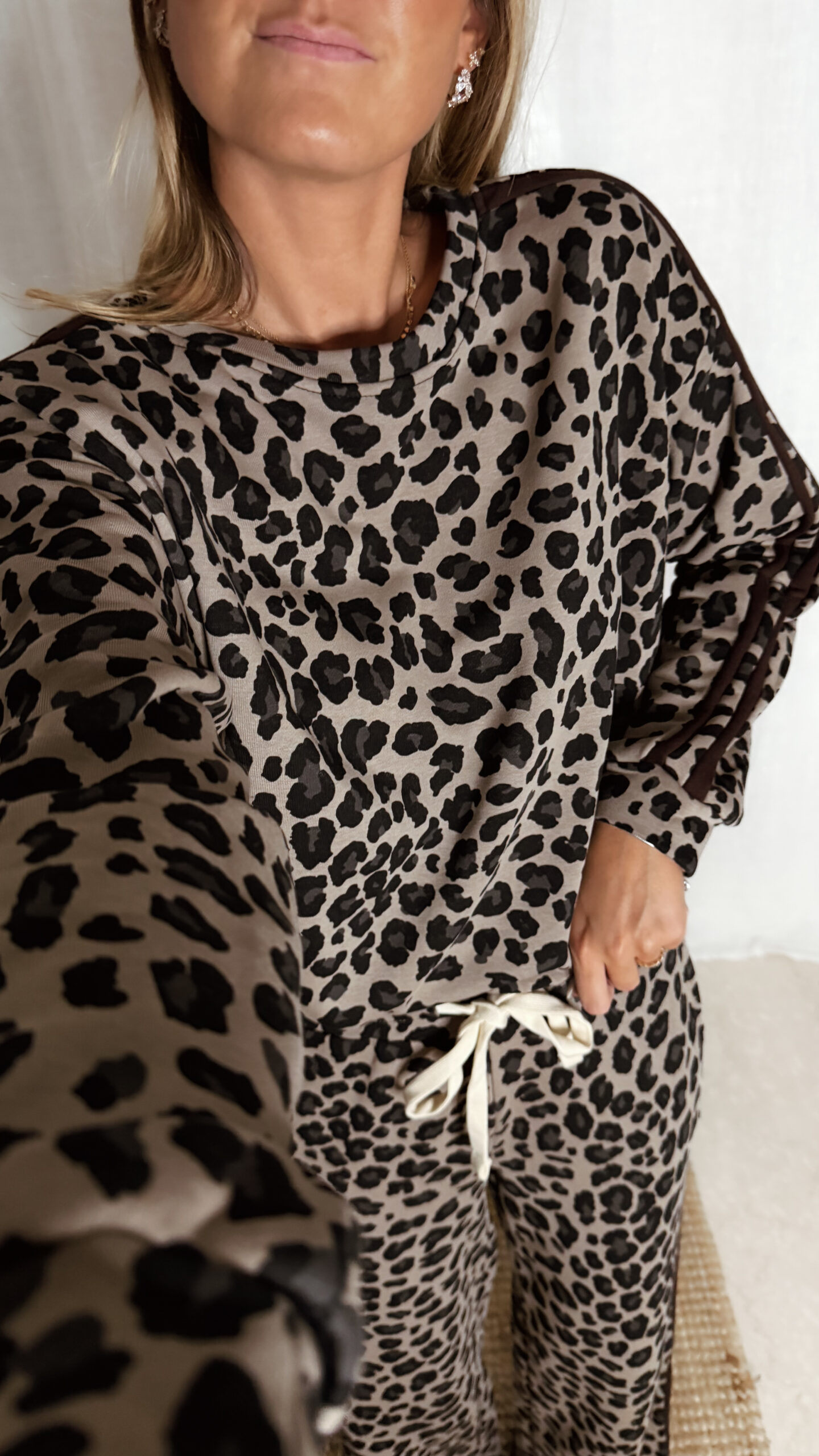 « Femme portant un ensemble jogging léopard composé d’un haut manches longues et d’un pantalon large à cordon, tenue décontractée tendance. »