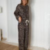 « Femme portant un ensemble jogging léopard composé d’un haut manches longues et d’un pantalon large à cordon, tenue décontractée tendance. »