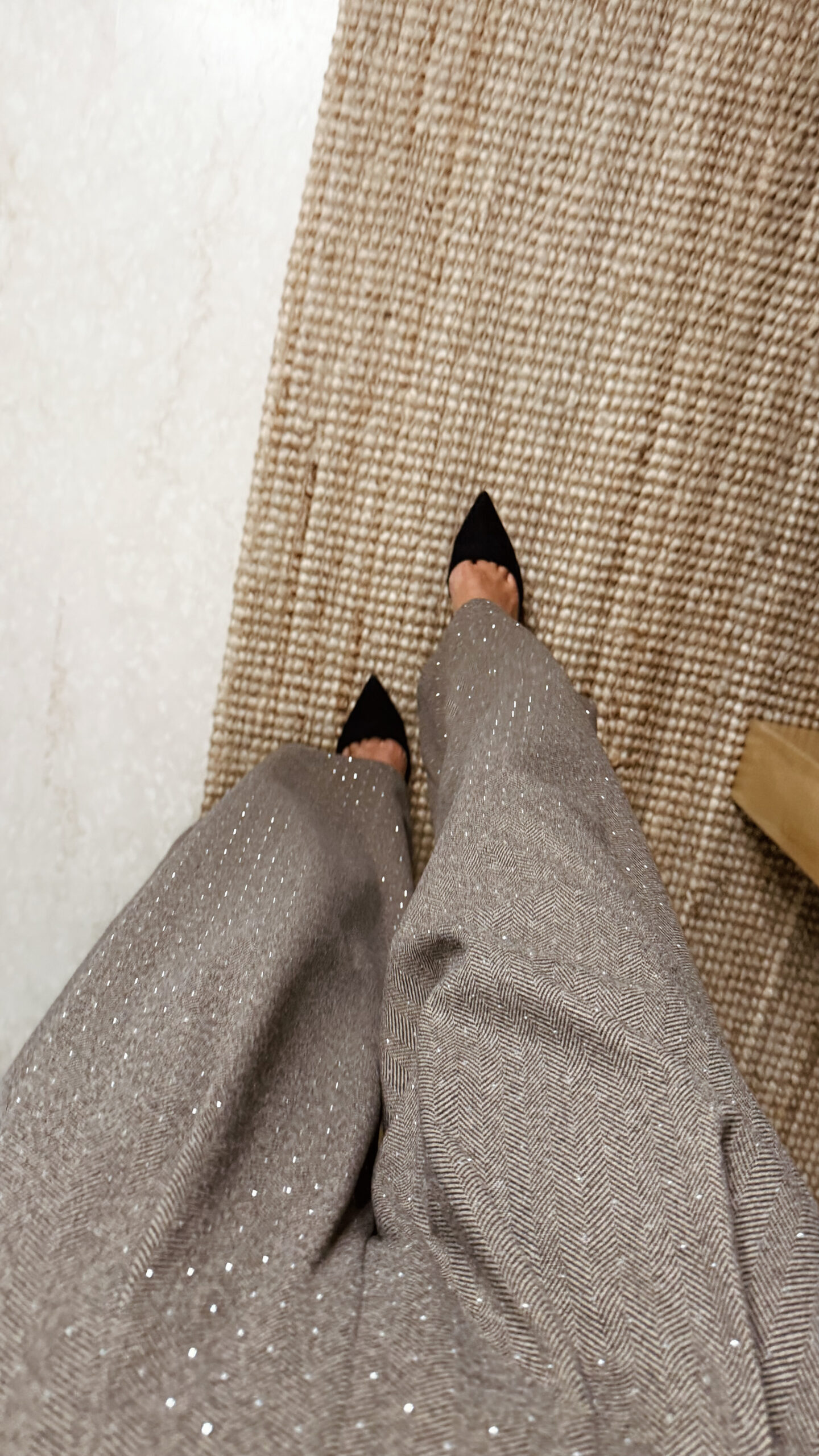 « Femme portant un body marron croisé à strass avec un pantalon large marron à chevrons et détails scintillants, tenue élégante chic. »