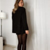 Femme portant un blazer noir à strass avec collants noirs et escarpins, tenue élégante et chic de soirée.
