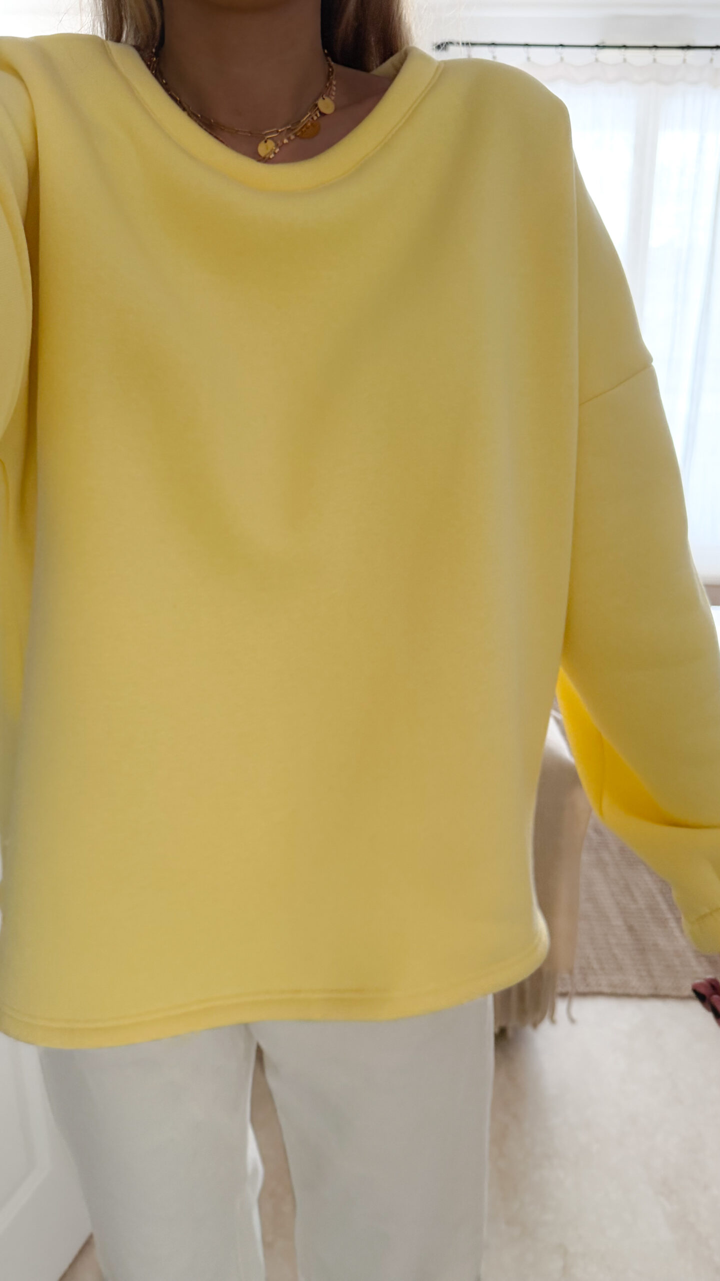 Sweat jaune à coupe ample, vu de dos, avec l’inscription brodée multicolore « GOOD VIBES ».