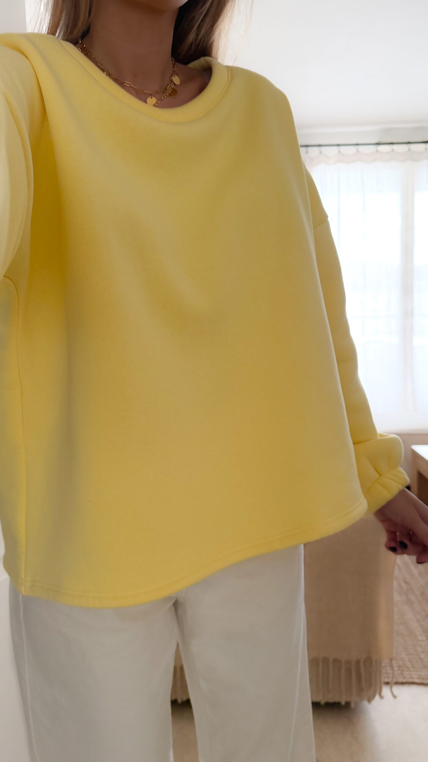 Sweat jaune à coupe ample, vu de dos, avec l’inscription brodée multicolore « GOOD VIBES ».