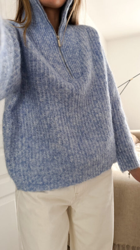 Pull camionneur bleu en maille douce, col zippé, porté avec un pantalon clair