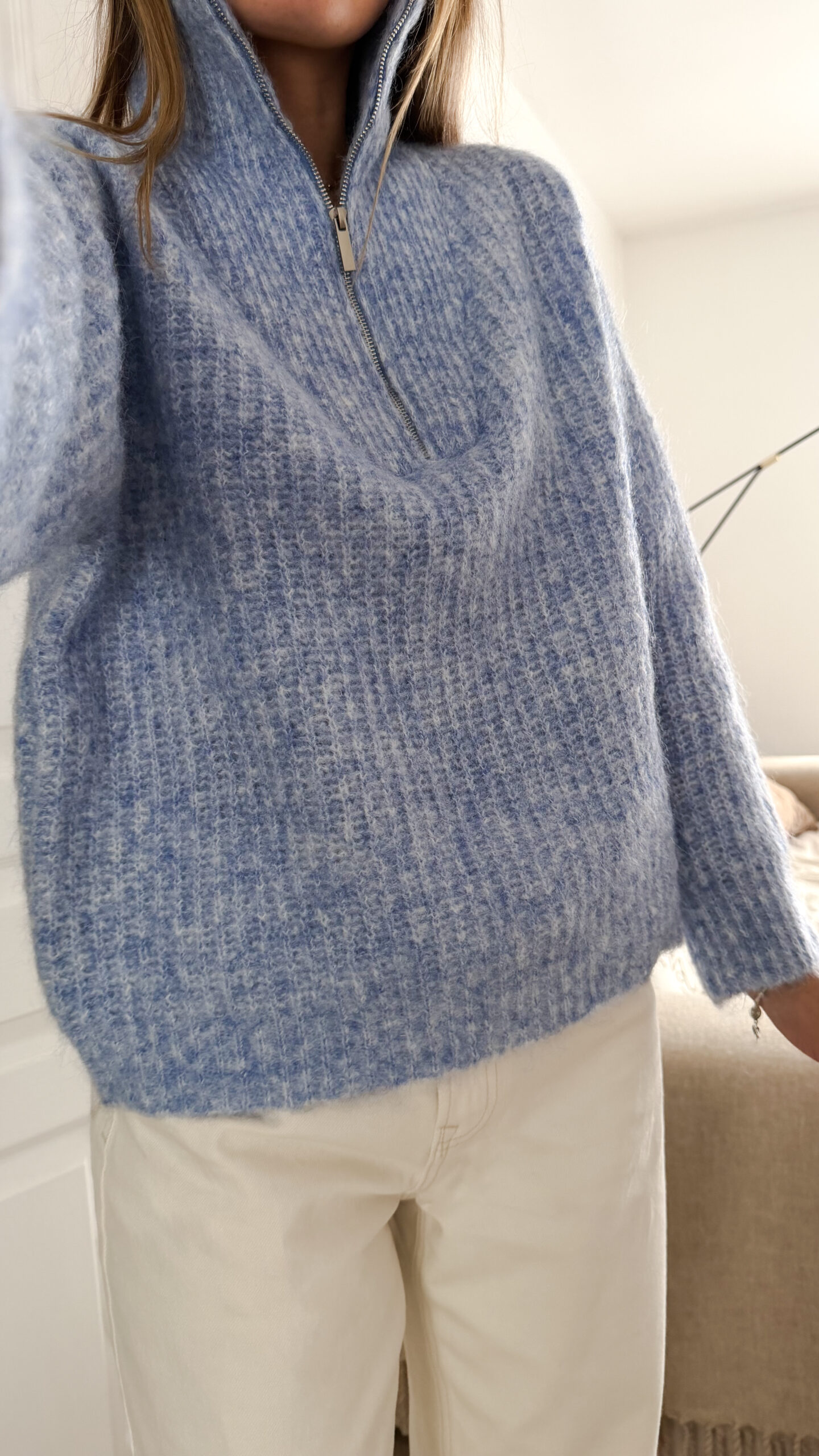 Pull camionneur bleu en maille douce, col zippé, porté avec un pantalon clair