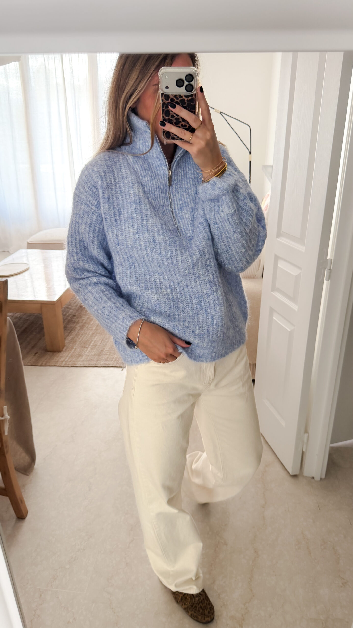 Pull camionneur bleu en maille douce, col zippé, porté avec un pantalon clair