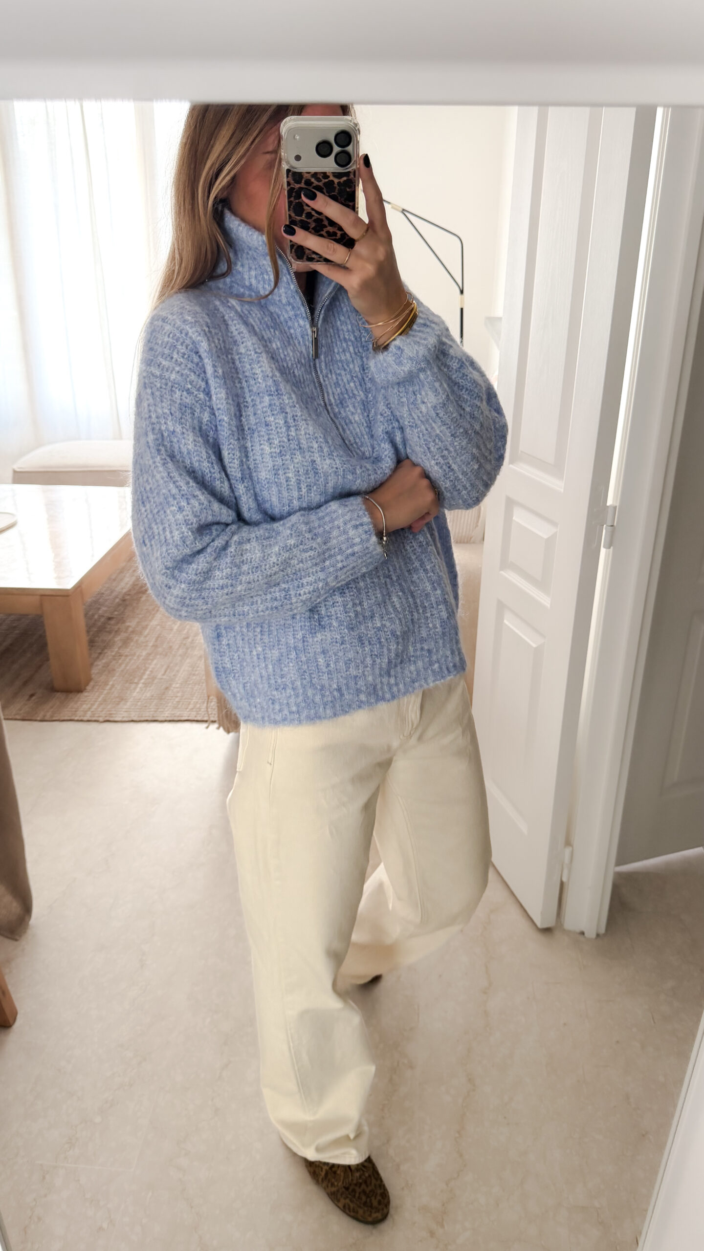 Pull camionneur bleu en maille douce, col zippé, porté avec un pantalon clair