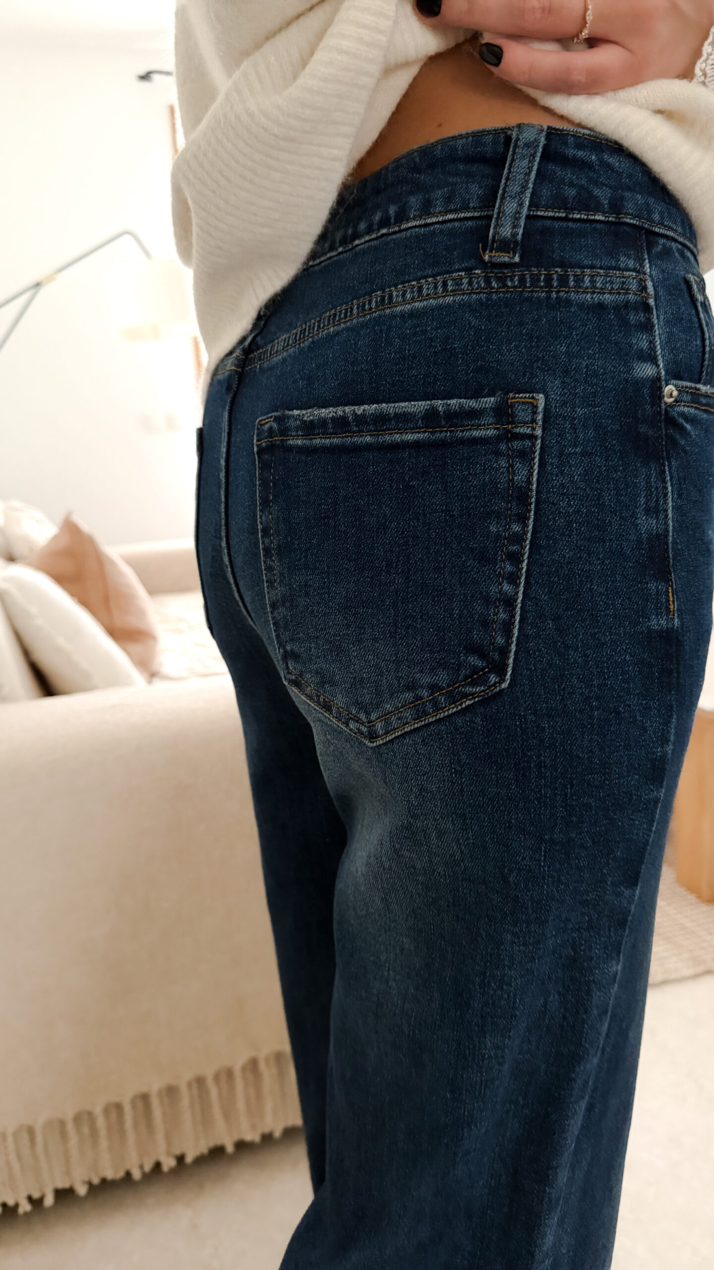 Jean flare bleu foncé avec un pull maille ecru et ses finition poignet dentelle