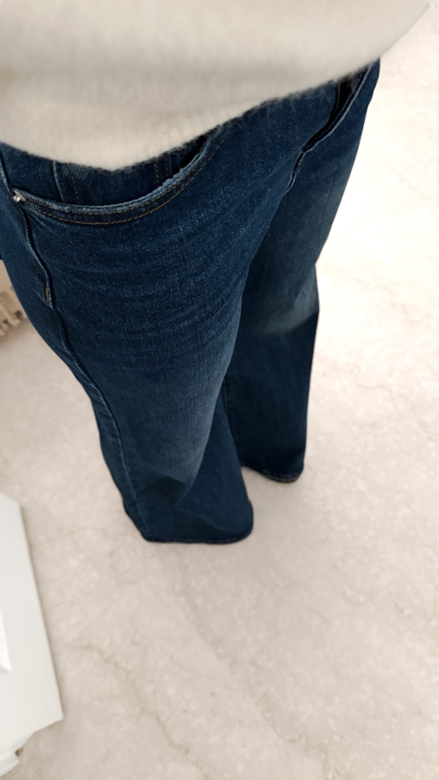 Jean flare bleu foncé avec un pull maille ecru et ses finition poignet dentelle