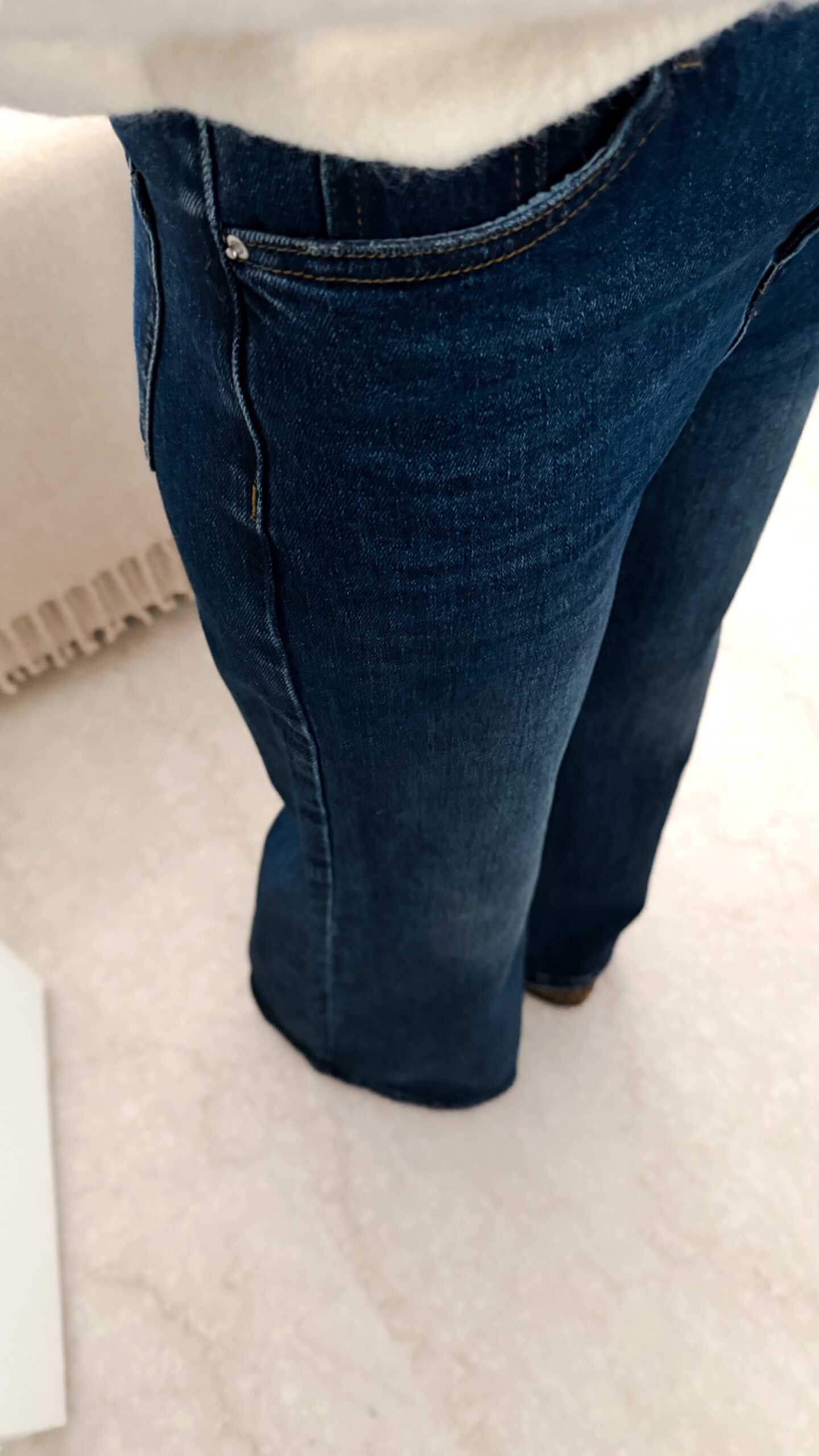 Jean flare bleu foncé avec un pull maille ecru et ses finition poignet dentelle