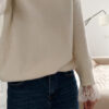 Jean flare bleu foncé avec un pull maille ecru et ses finition poignet dentelle