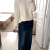 Jean flare bleu foncé avec un pull maille ecru et ses finition poignet dentelle
