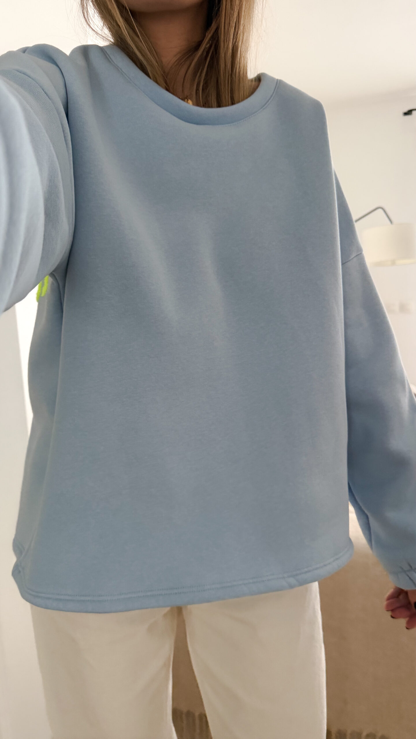 Sweat bleu ciel à coupe ample, vu de dos, avec l’inscription brodée multicolore « GOOD VIBES ».