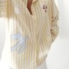 Chemise femme rayée jaune et blanche avec broderies estivales et inscription "La Dolce Vita"