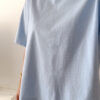 Femme portant un t-shirt oversize bleu clair avec un short blanc taille haute