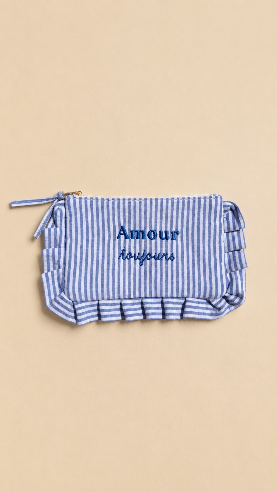 Collection de pochettes colorées à rayures et motifs vichy avec volants décoratifs et messages brodés, présentées sur un fond beige dans un style féminin et tendance.Rayures, vichy, volants et messages brodés : les accessoires parfaits pour glisser un peu de bonne humeur et beaucoup de style dans votre quotidien. À emporter partout, de la plage à la ville. ✨