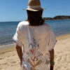 Ensemble femme bohème chic bleu à motif cachemire composé d'une chemise fluide et d'un short léger, porté sur une plage en été.
