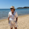 Ensemble femme bohème chic bleu à motif cachemire composé d'une chemise fluide et d'un short léger, porté sur une plage en été.