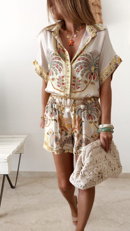 Ensemble femme bohème chic beige à motif cachemire composé d'une chemise fluide et d'un short léger, porté sur une plage en été.