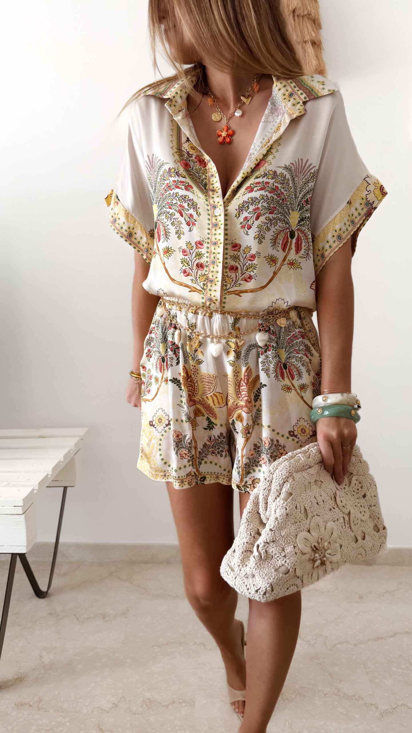 Ensemble femme bohème chic beige à motif cachemire composé d'une chemise fluide et d'un short léger, porté sur une plage en été.