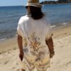 Ensemble femme bohème chic beige à motif cachemire composé d'une chemise fluide et d'un short léger, porté sur une plage en été.