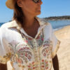Ensemble femme bohème chic beige à motif cachemire composé d'une chemise fluide et d'un short léger, porté sur une plage en été.